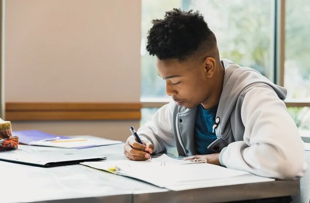 A student focused on his studies at a table